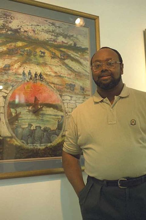 A man standing in front of a painting.
